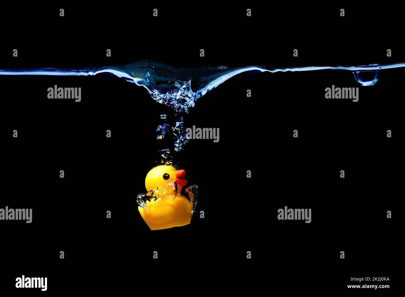 Toy duck splashing in water isolated on black background. Stock Photo