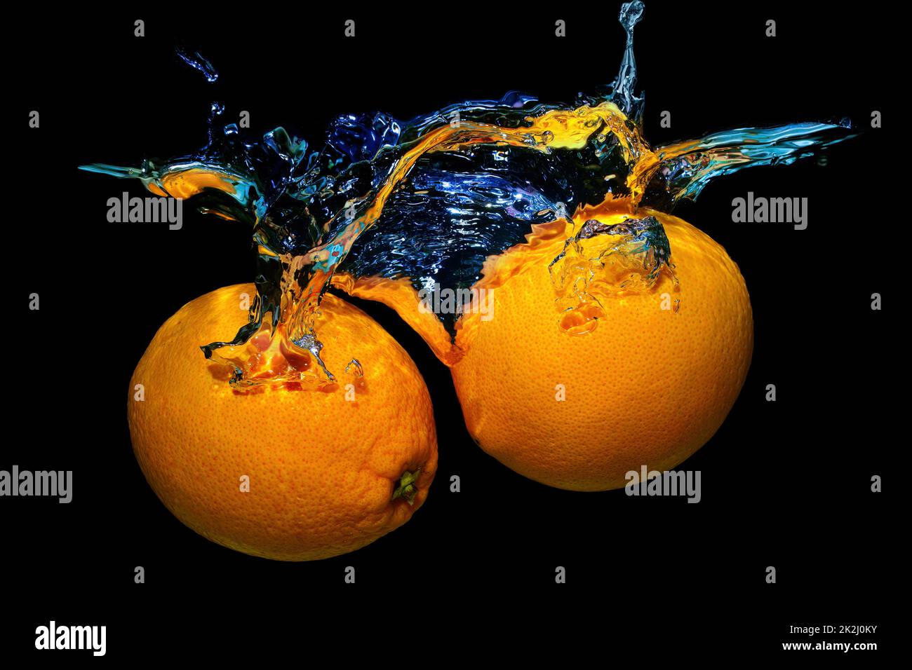 Two fresh oranges in water splashes isolated on black background. Stock Photo
