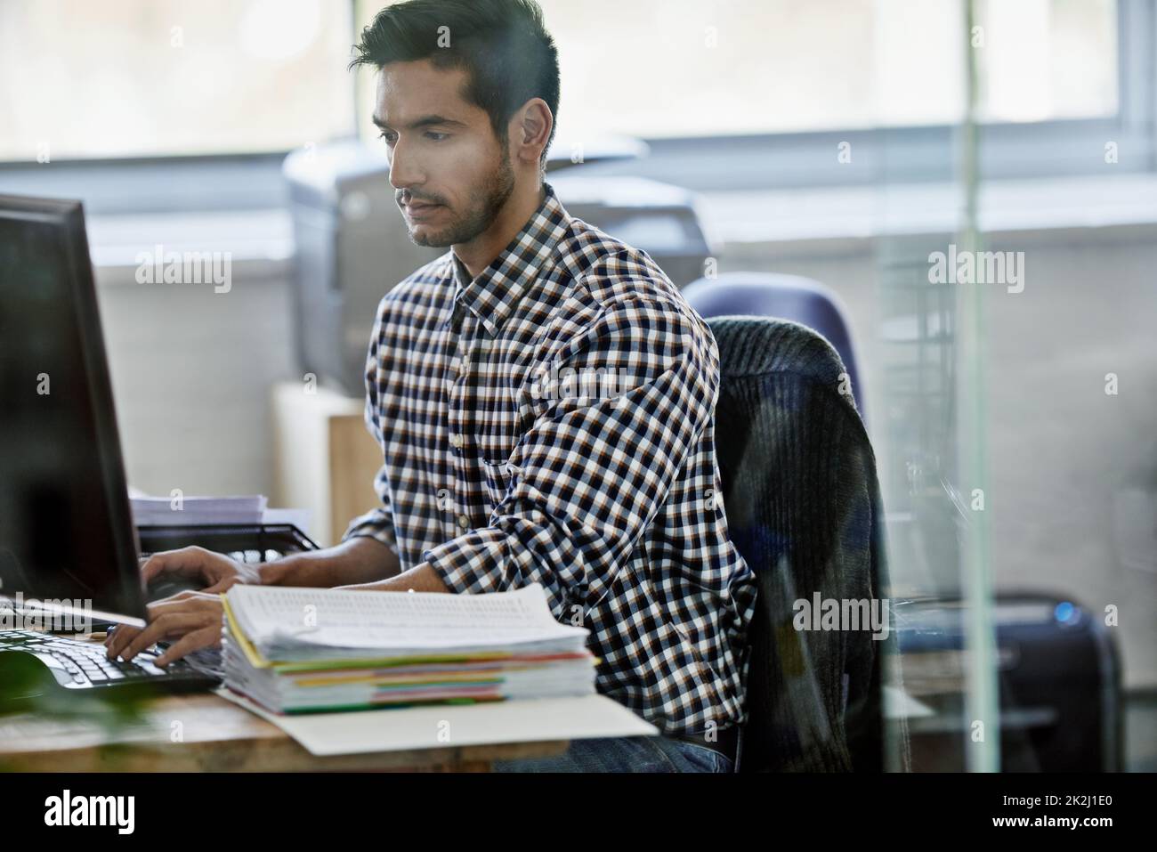 Coming up with a fool-proof plan. Cropped shot of a handsome young designer working on a pc. Stock Photo