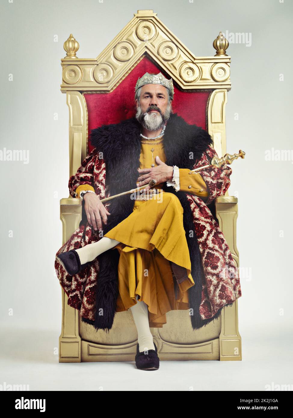 I took the throne peacefully. Studio shot of a richly garbed king sitting on a throne. Stock Photo