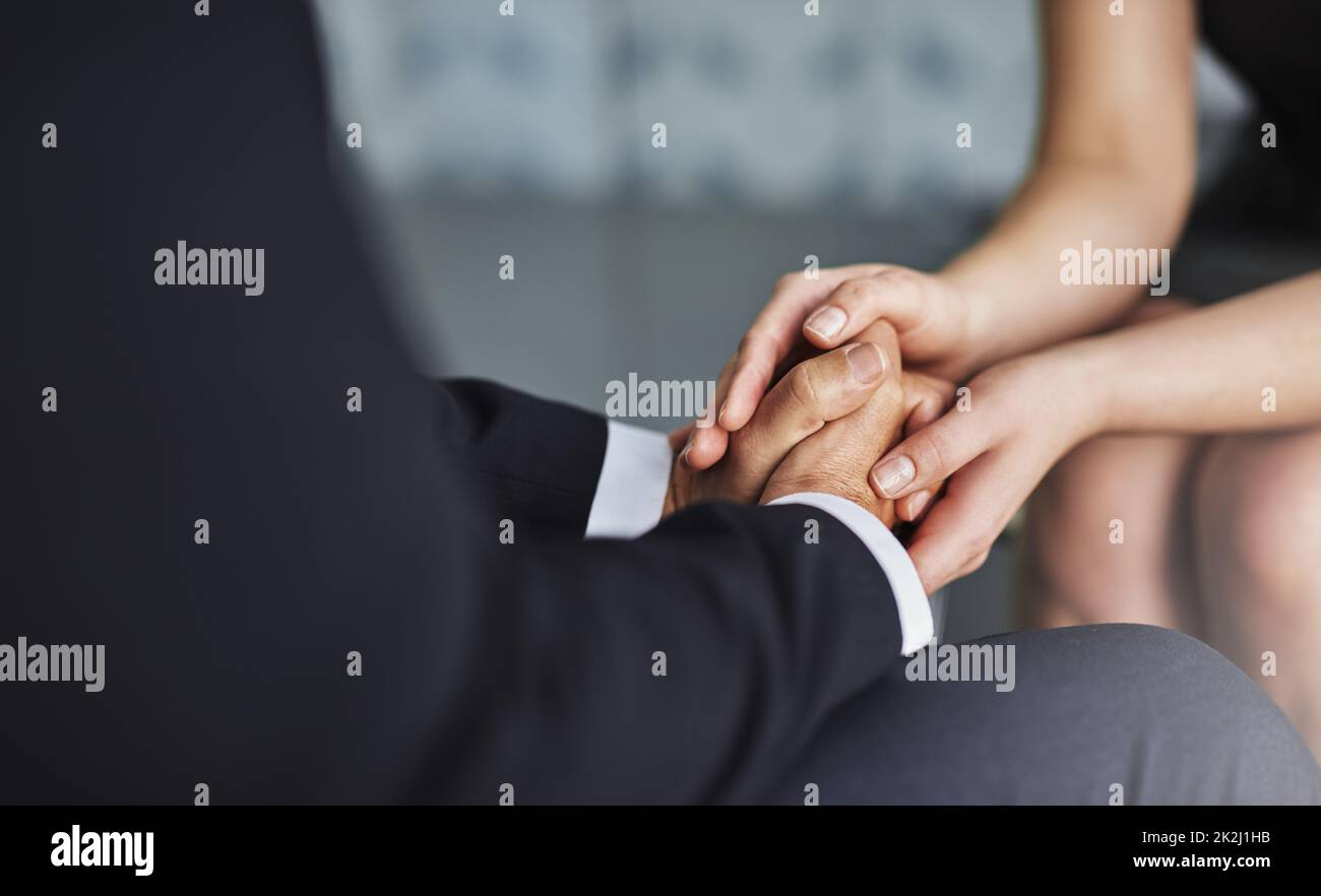 Acknowledgment is another form of generosity. Cropped shot of two compassionate colleagues holding hands. Stock Photo