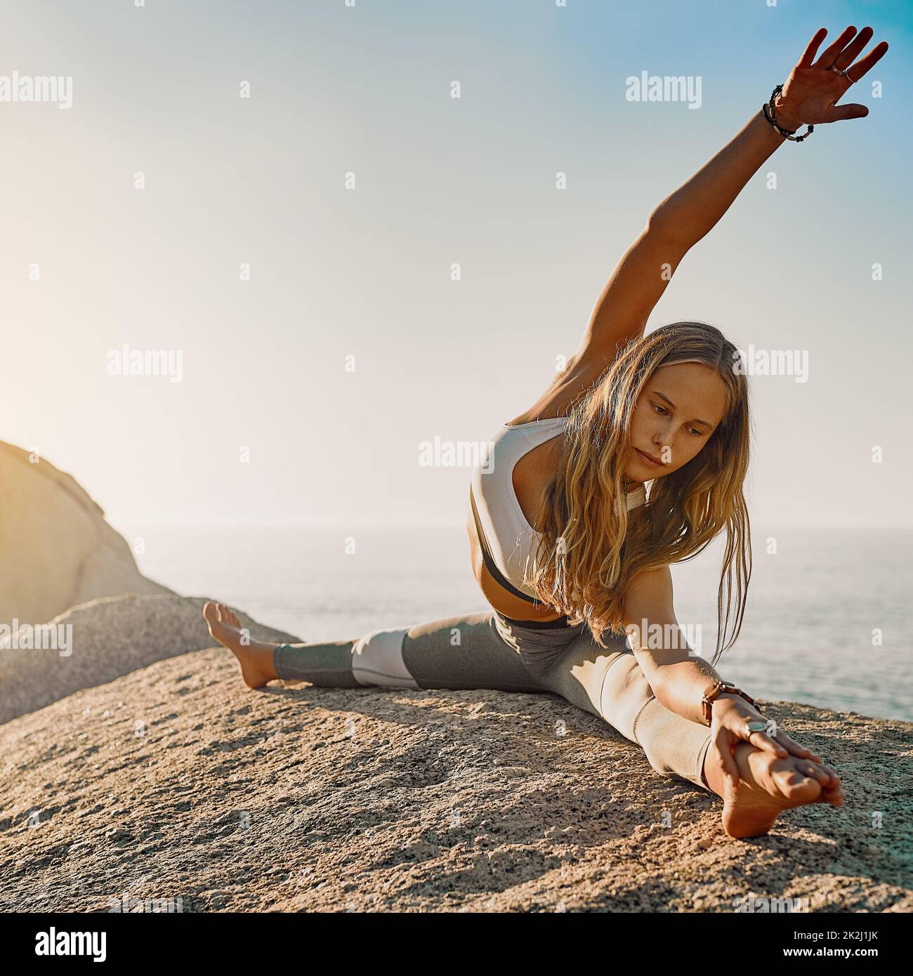 Stay patient and trust your journey. Shot of an athletic young woman practicing yoga on the beach. Stock Photo
