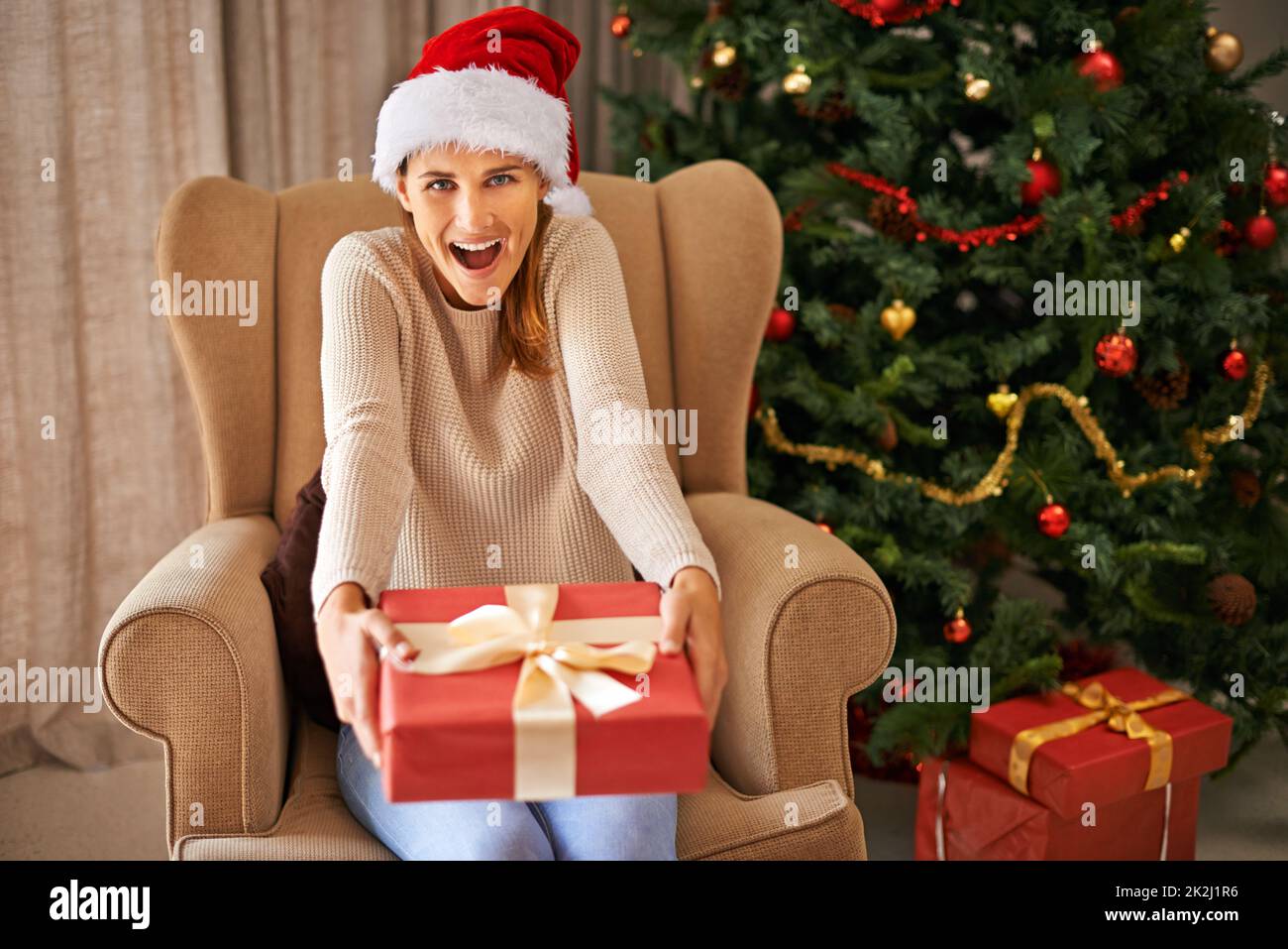 For me. Portrait of a beautiful young woman holding a Christmas gift ...