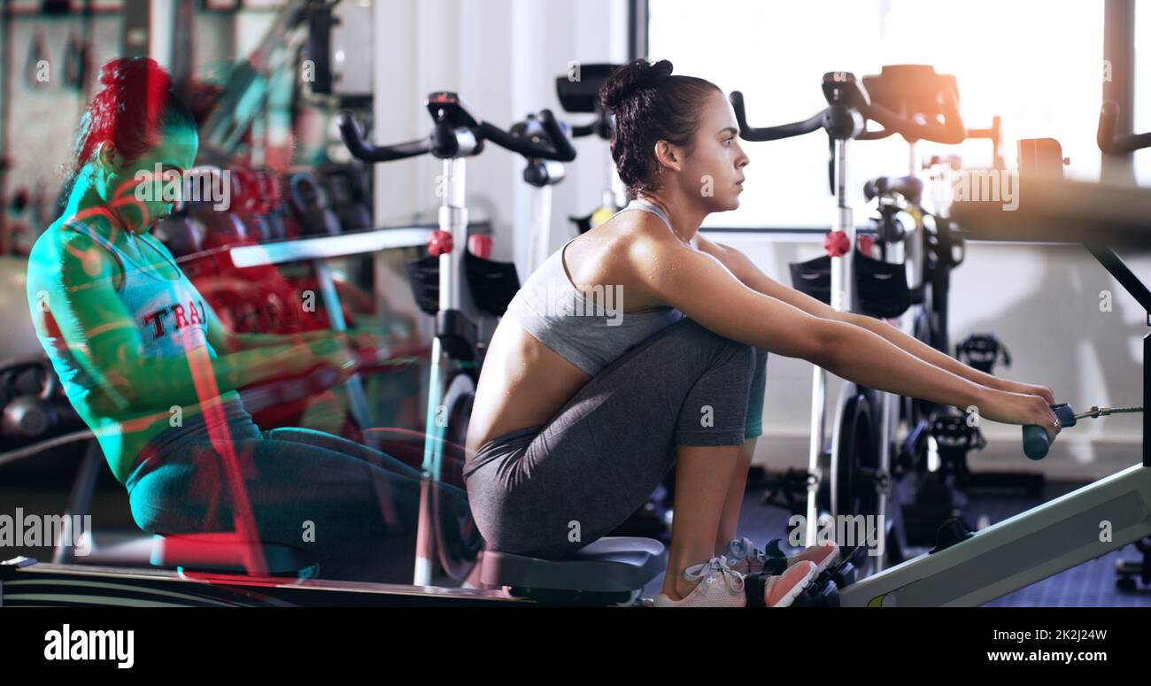 Getting her row on. Cropped shot of an attractive young woman working out on a rowing machine in the gym. Stock Photo