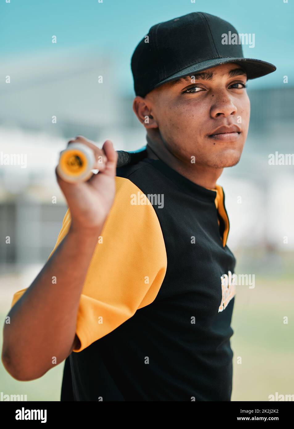 I dont run away from challenges, I run over them. Shot of a young baseball player holding a baseball bat while posing outside on the pitch. Stock Photo