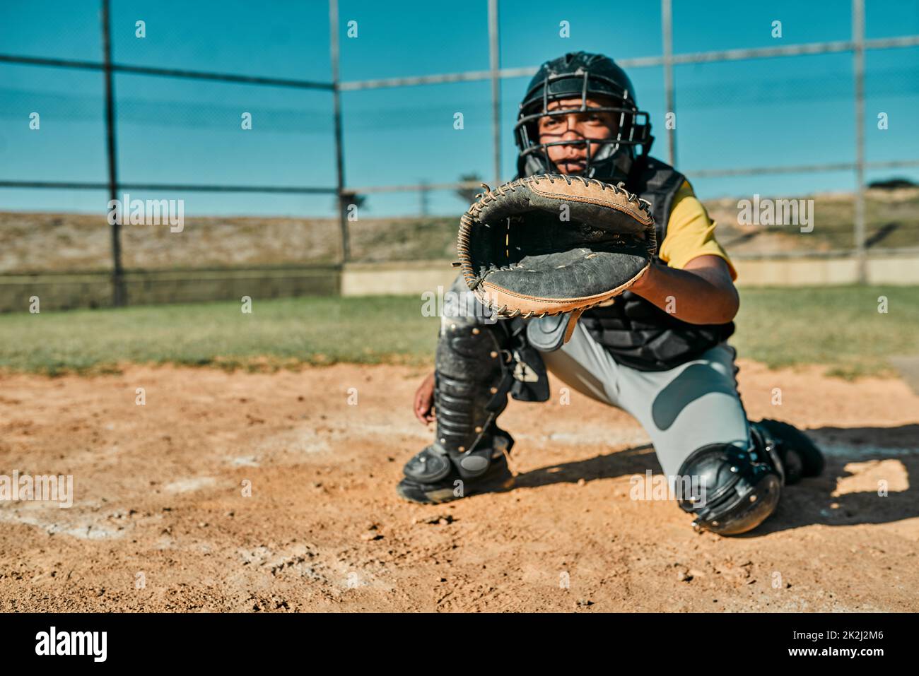 Hes keeping his eye on the ball. Shot of the catcher sitting in