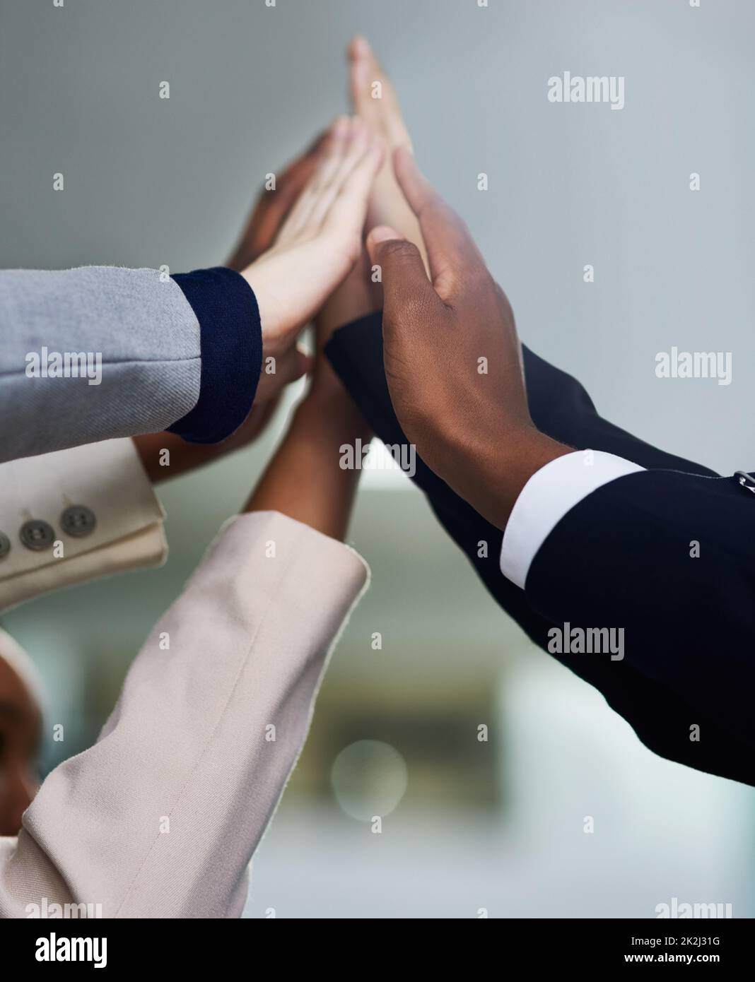 With teamwork, success is inevitable. Cropped shot of a group of colleagues giving each other a high five. Stock Photo