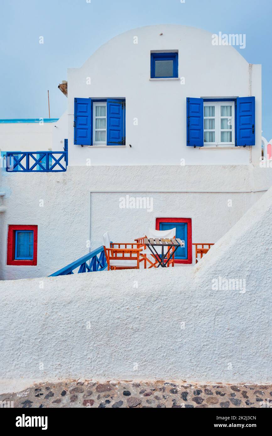 Greek white house with blue door and window blinds Oia village on Santorini island in Greece Stock Photo