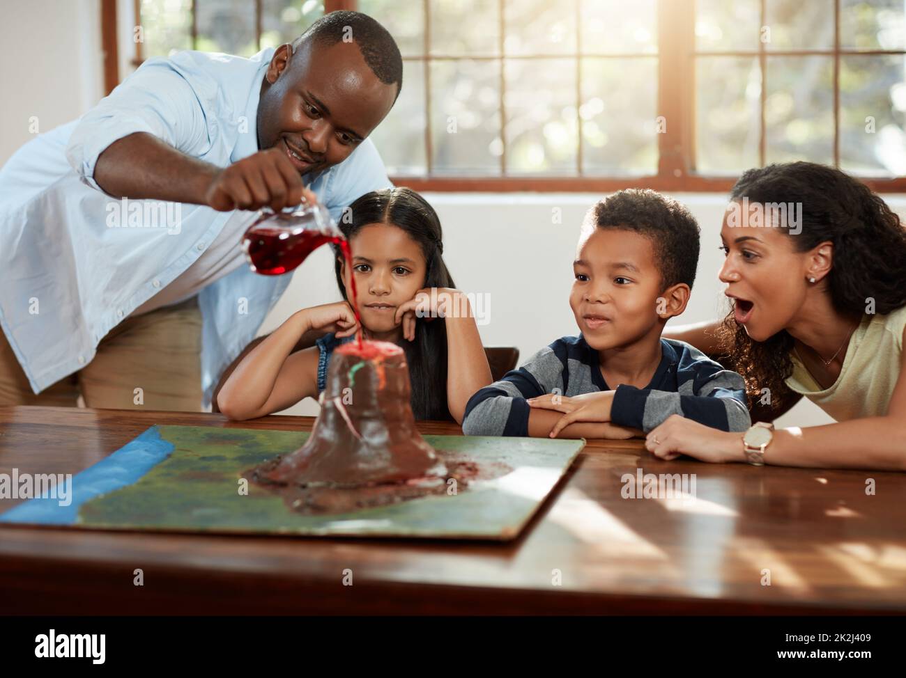 Time to test this thing out. Cropped shot of a young couple helping their kids with a school project. Stock Photo