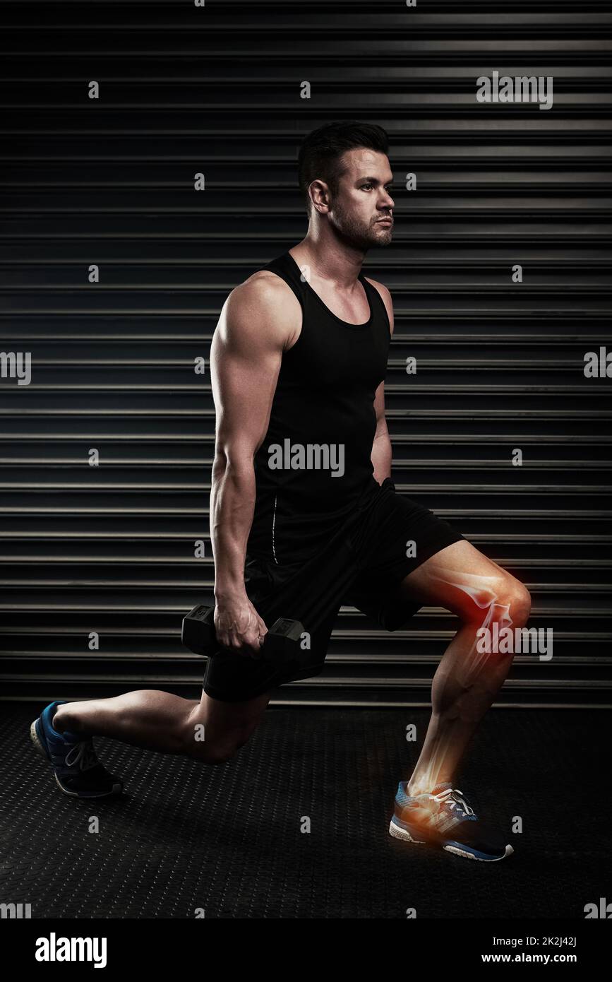 Lunges can put strain on your knees. Full length shot of an athletic young man working out with dumbbells in the studio. Stock Photo