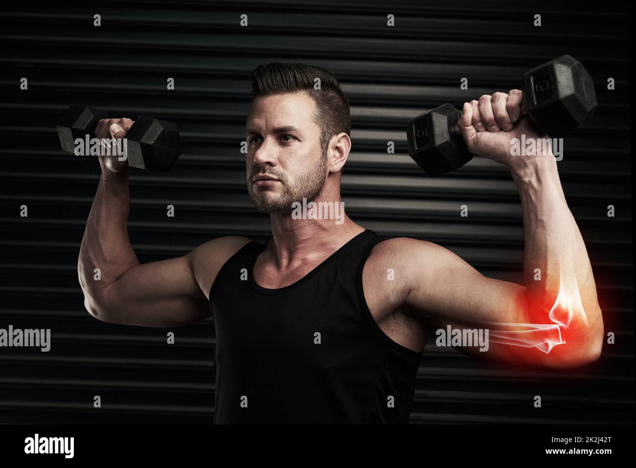 Raising his fitness levels. Studio shot of an athletic young man working out with dumbbells. Stock Photo