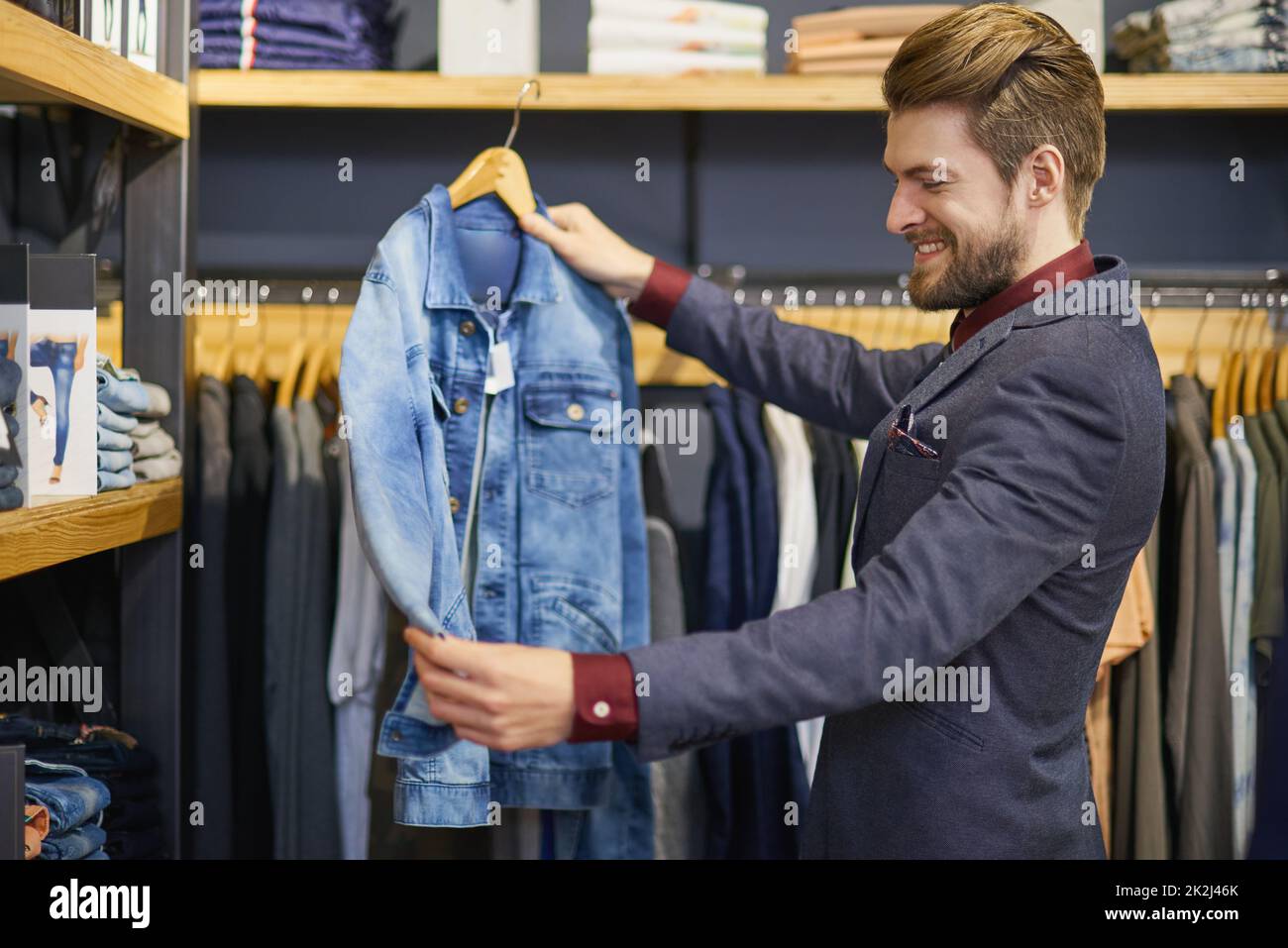 https://c8.alamy.com/comp/2K2J46K/everyone-needs-a-classic-denim-jacket-in-their-closet-shot-of-a-young-man-looking-at-clothes-in-a-boutique-2K2J46K.jpg