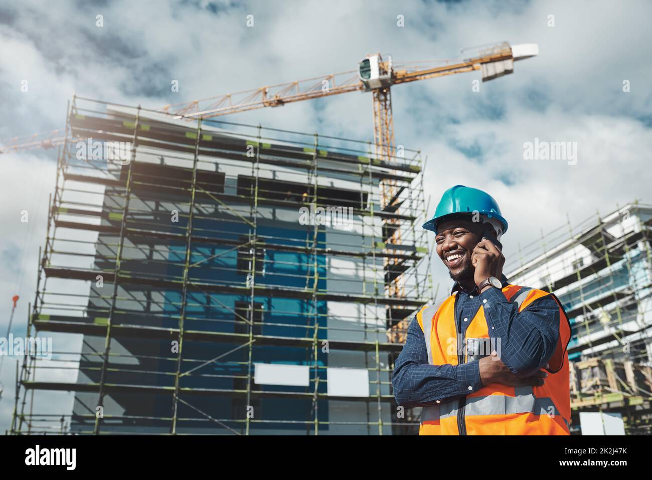 The best building contractor on the block. Shot of a young man using a smartphone while working at a construction site. Stock Photo