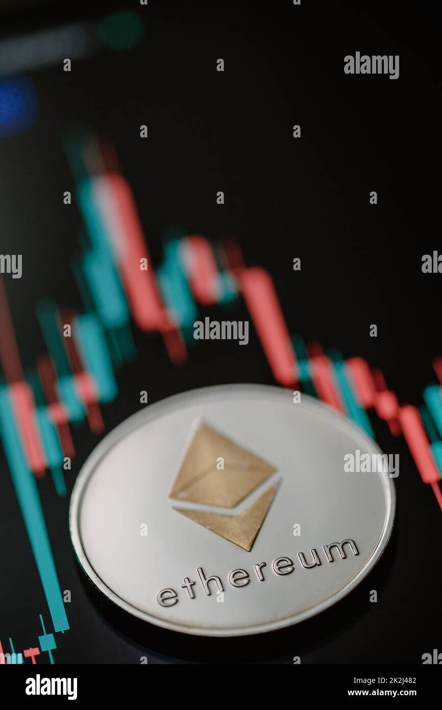 Silver Ethereum cryptocurrency with candle stick graph chart and digital background. Stock Photo