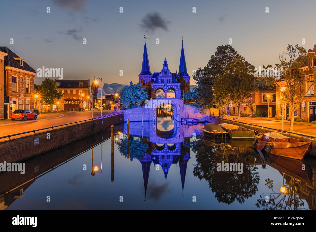 An evening at the famous Waterpoort, illuminated in blue. The Waterpoort or Hoogendster Pijp is a water gate, a gate in a defensive wall that connects Stock Photo