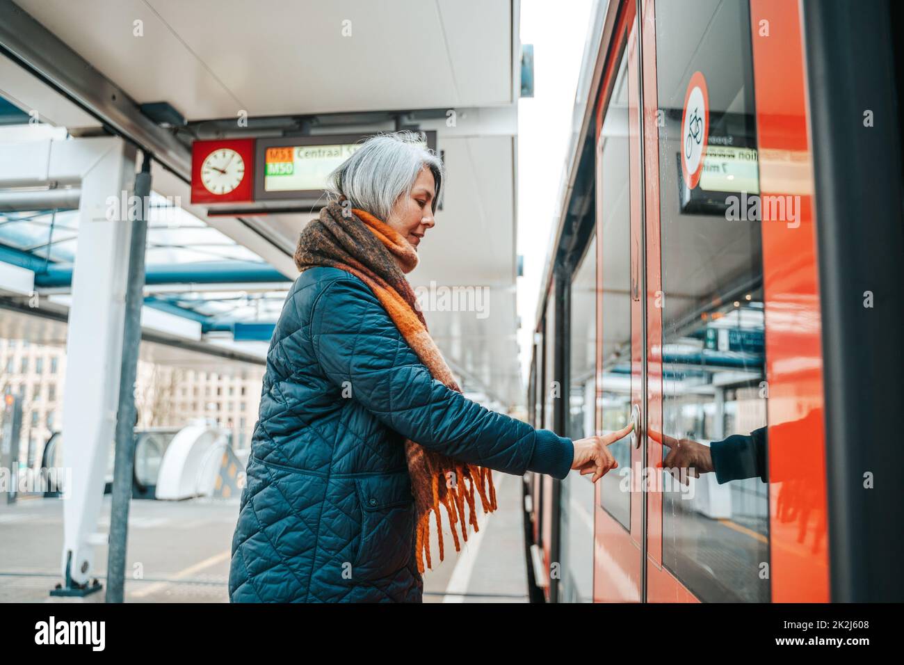 Senior woman press the button to open the door of the train Stock Photo ...