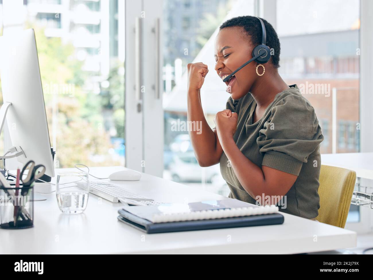 A good sale puts me in a good mood. Shot of a businesswoman looking cheerful while working in a call centre. Stock Photo