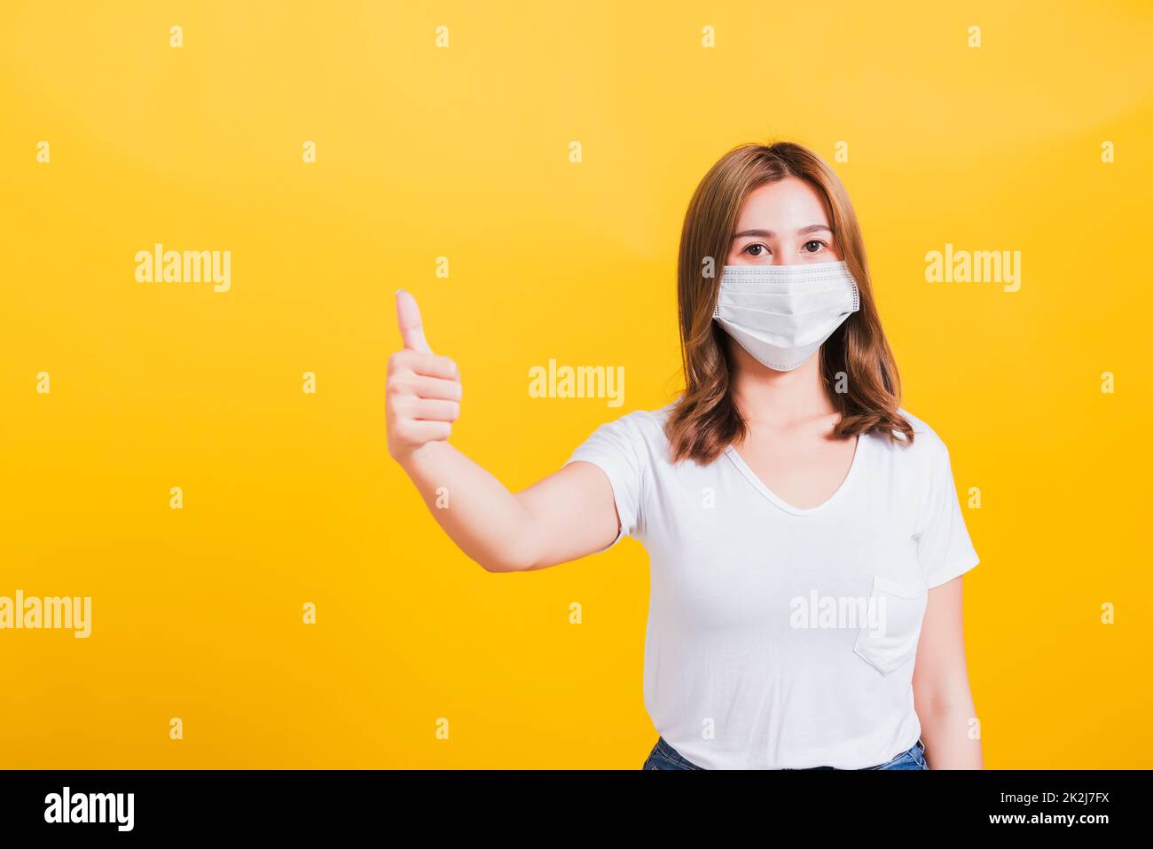woman wearing mask protection, show thumb finger good stopping virus outbreak control Stock Photo