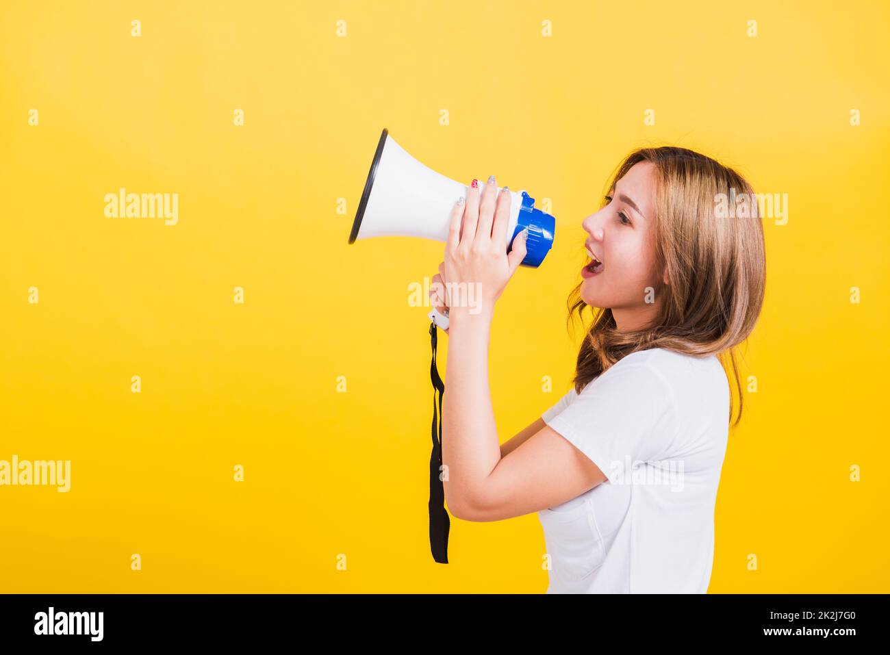 woman teen standing making announcement message shouting screaming in megaphone Stock Photo