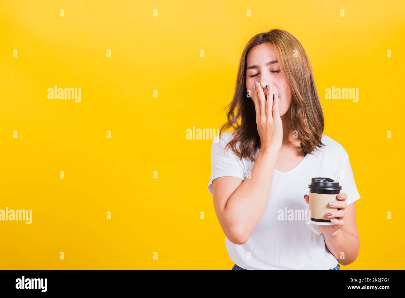 Woman Tired sleepy her cannot wake up and closes eyes holds take away cup coffee Stock Photo