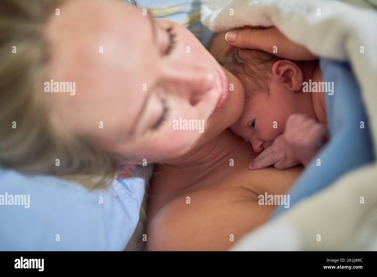 Ill cherish this gift of life forever. Shot of a beautiful young mother lying in bed with her newly born baby girl in the hospital. Stock Photo
