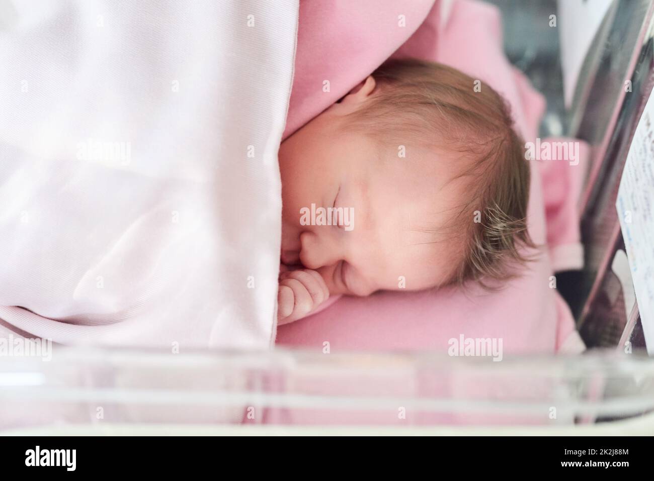 She needs all the sleep she can get. Shot of a newly born baby girl in the hospital. Stock Photo