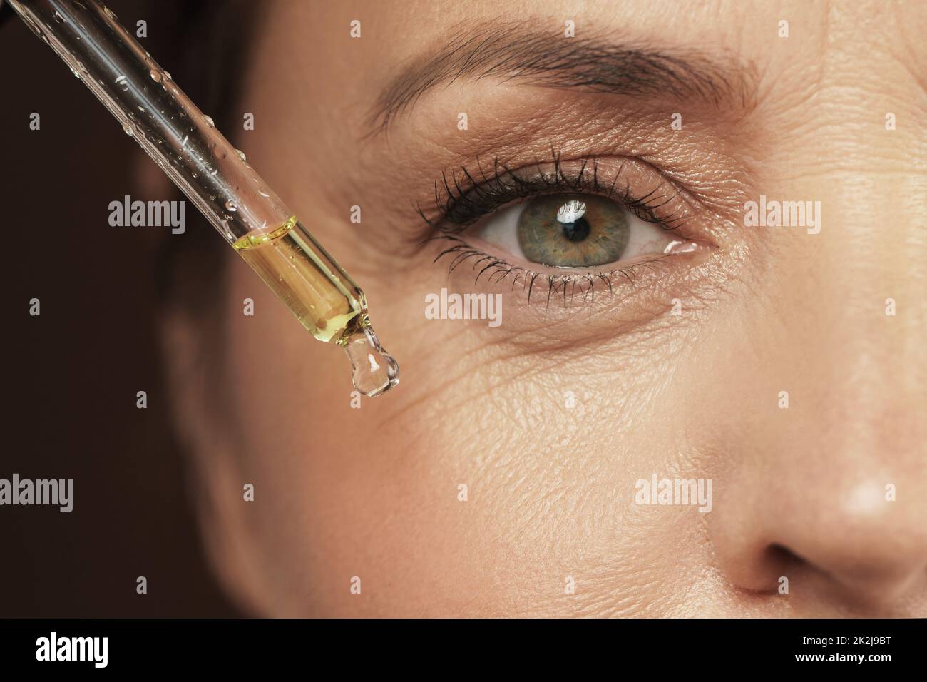 Female eye and dropper with rejuvenating serum Stock Photo