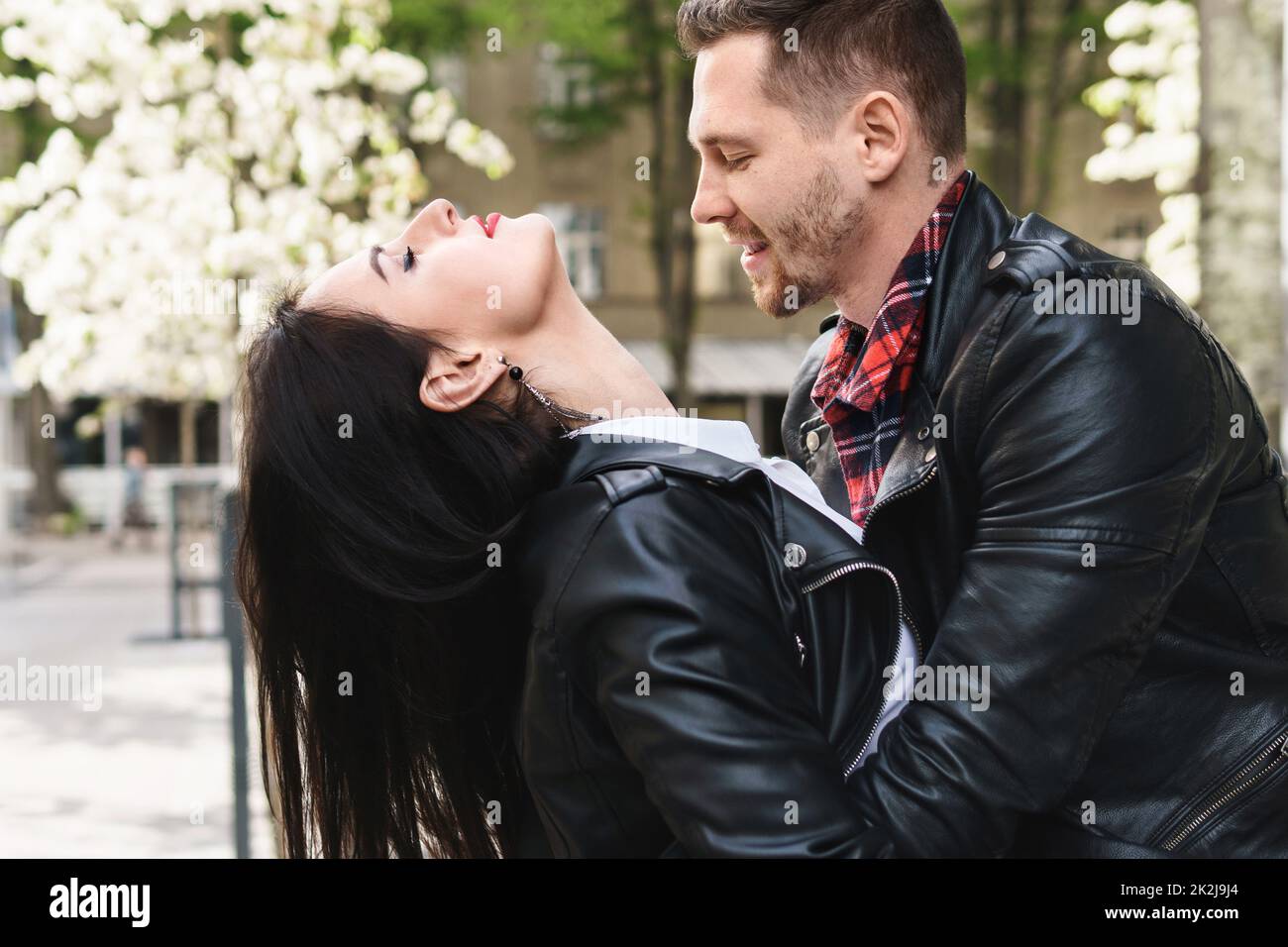 Beautiful couple in love wearing leather jackets during a date on a city street Stock Photo