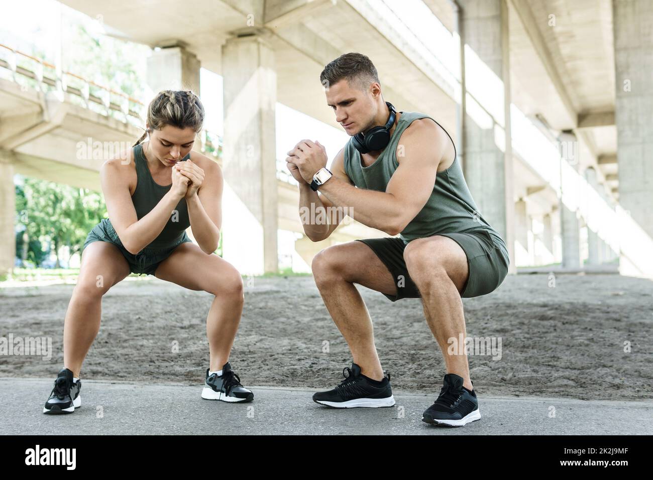Athletic couple doing squats during street workout Stock Photo