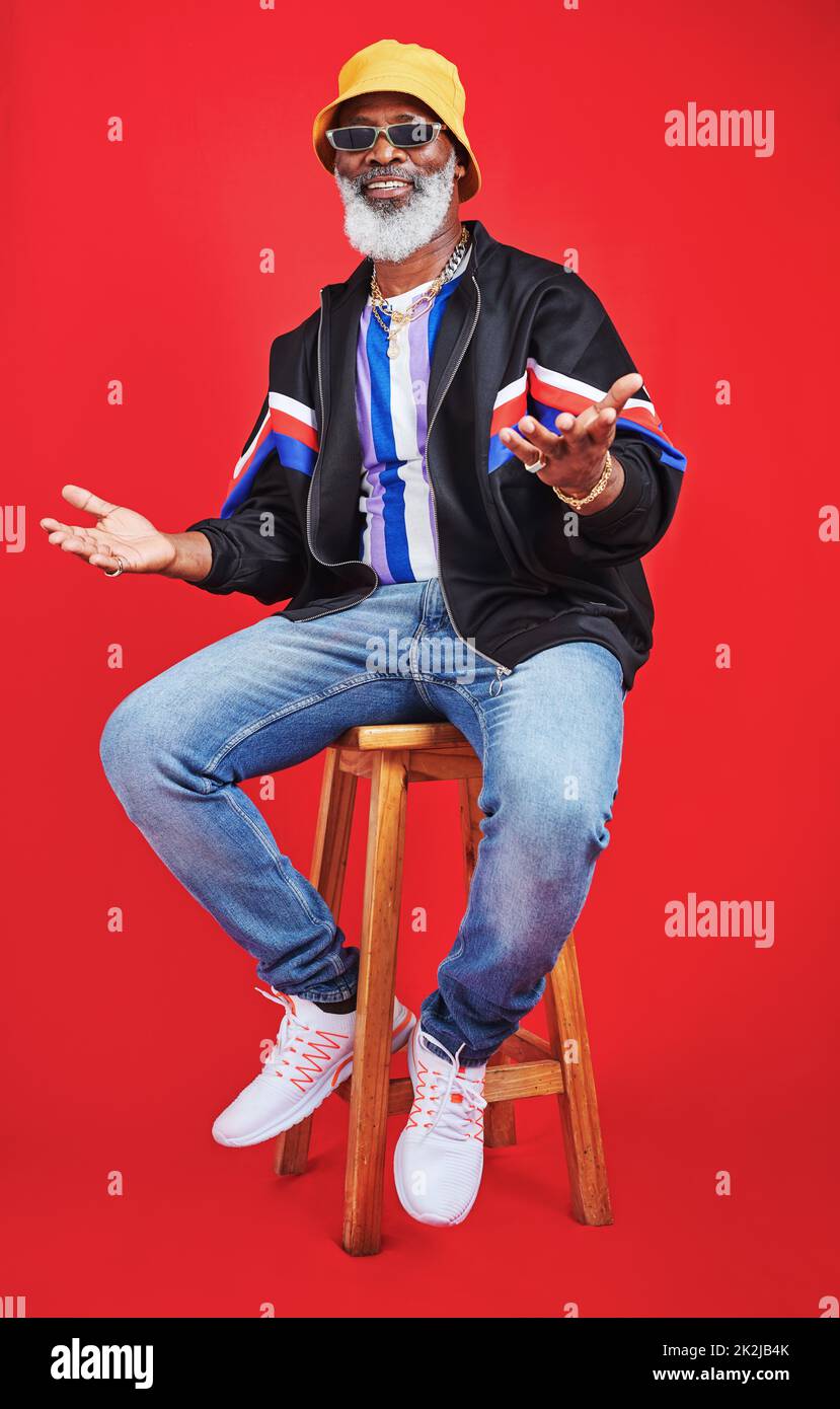 I still dress good. Studio shot of a senior man wearing retro attire while posing against a red background. Stock Photo