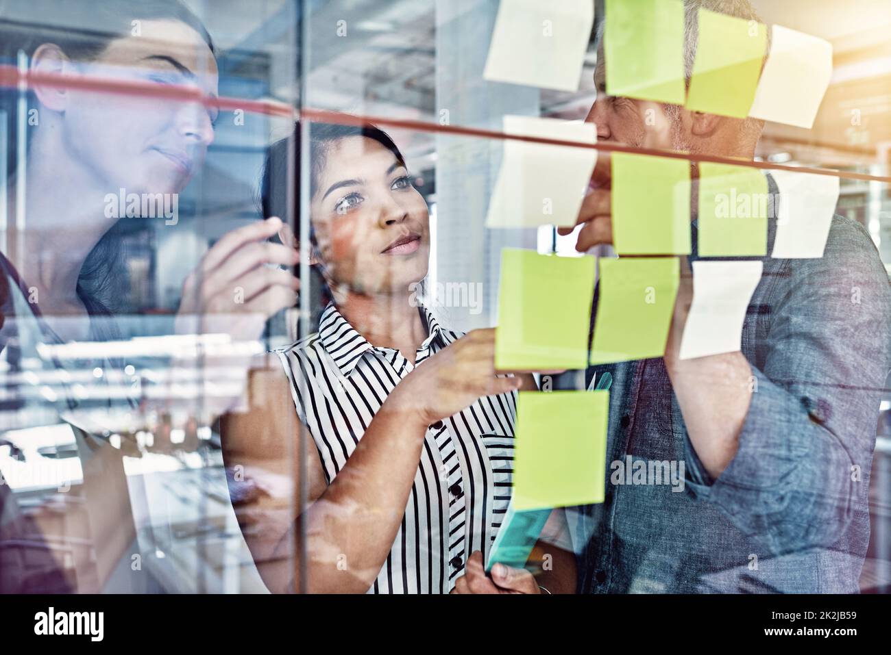 Theyre organised. Cropped shot of three colleagues looking at sticky ...