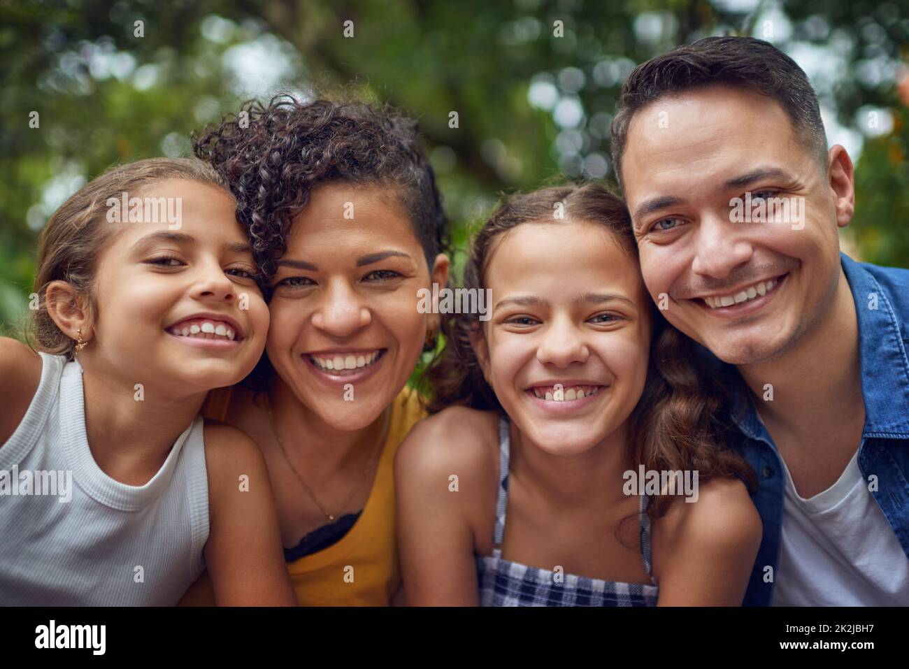 What a cute smile-filled family. Cropped portrait of a happy family spending some time together at the park. Stock Photo