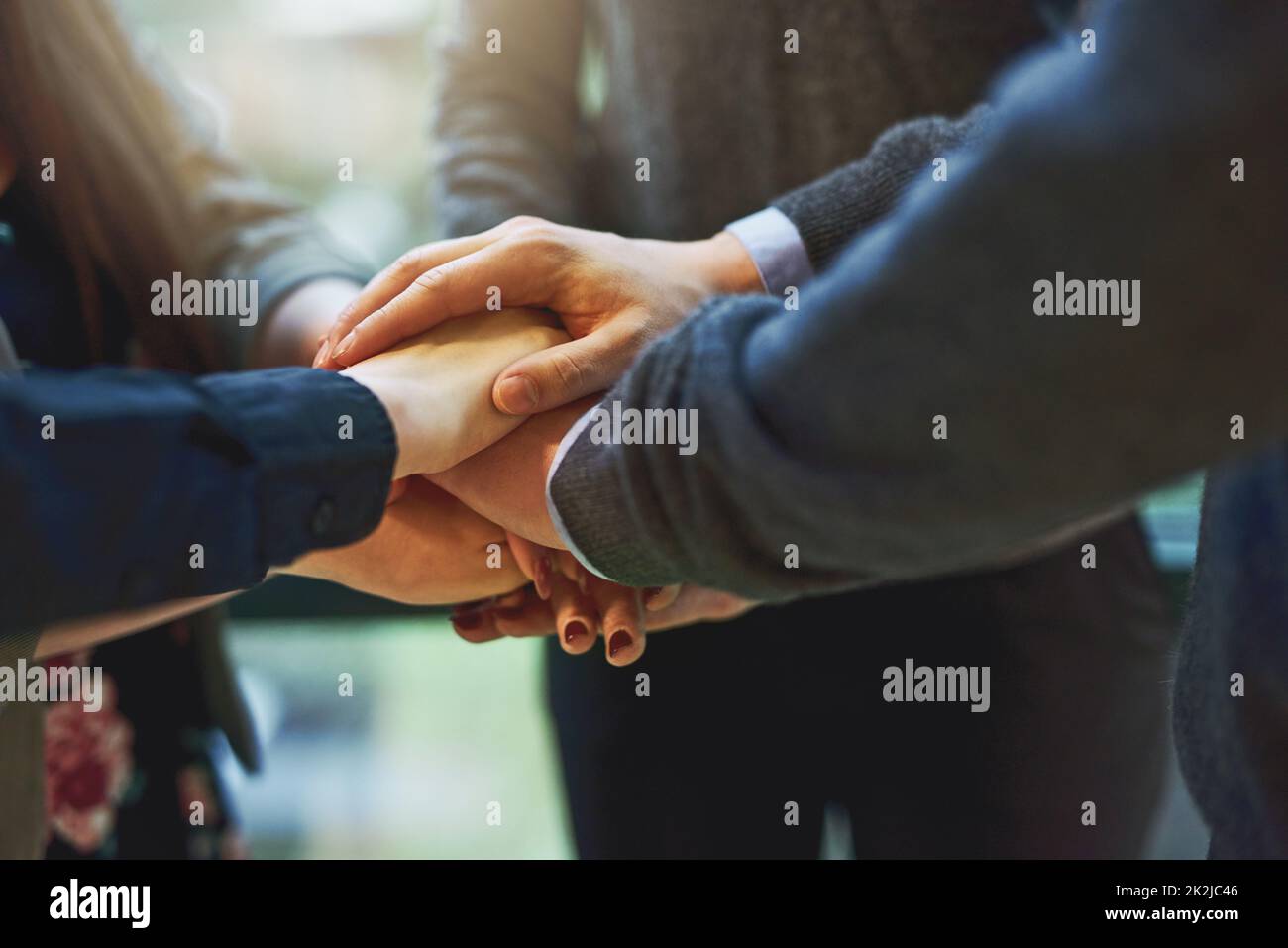 The business team to beat. Cropped shot of a group of unrecognizable businesspeople huddled together with their hands piled on top of each other in an office. Stock Photo