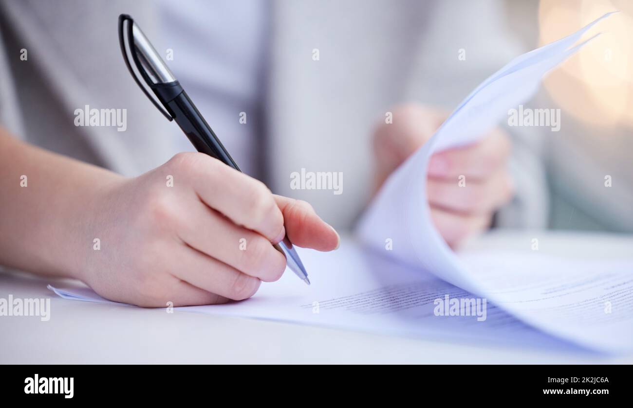 The paperworks piled up. Shot of an unrecognizable businessperson going through paperwork at work. Stock Photo