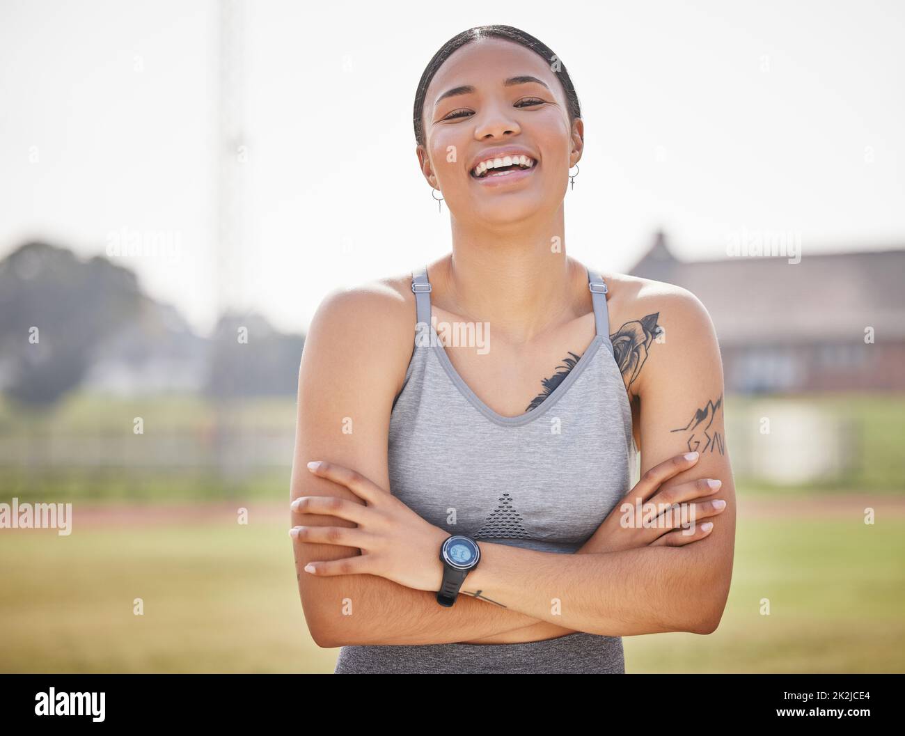 I love competing. Cropped portrait of an attractive young female athlete standing outside on the track with her arms folded. Stock Photo