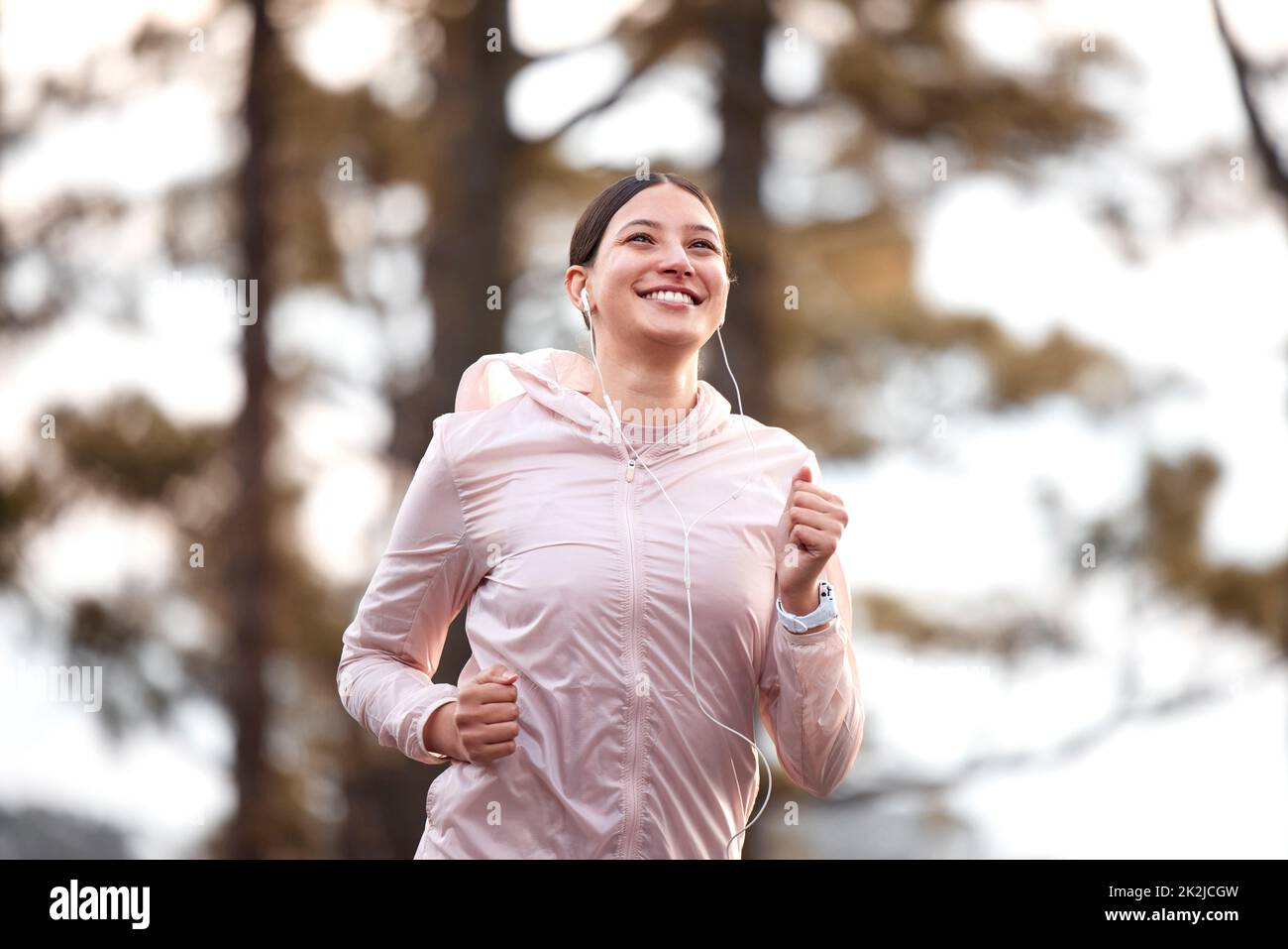 Nothing like a run to clear the mind. Shot of a young female athlete running in nature. Stock Photo