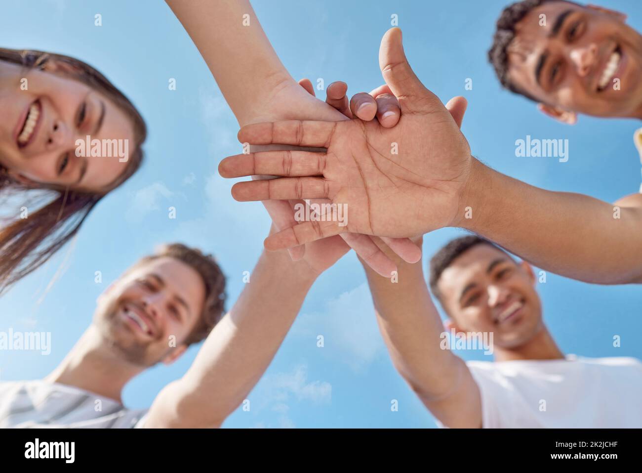 Were the best team. Low angle shot of a group of young people stacking their hands. Stock Photo