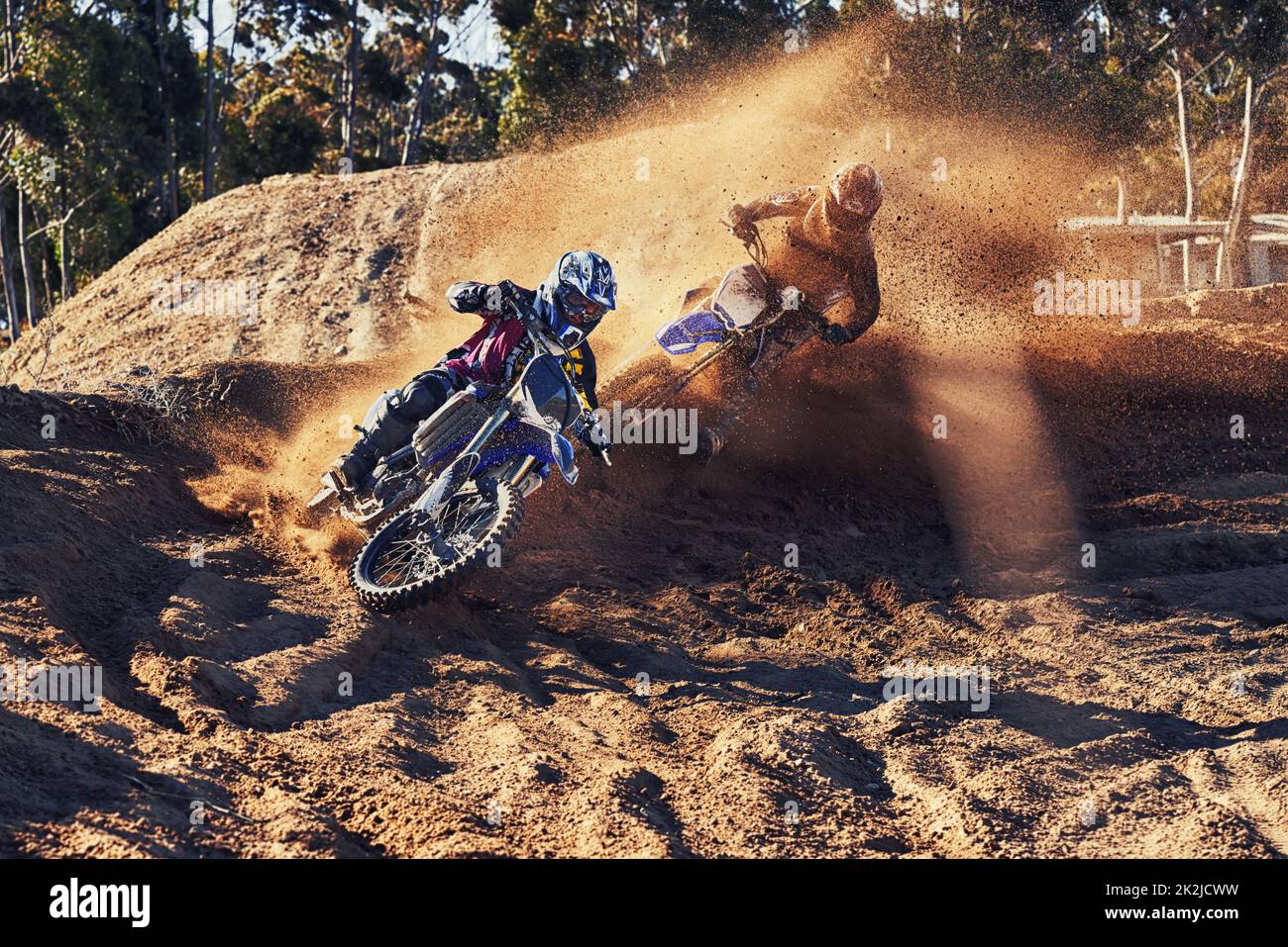 Time to rip up this track. Shot of a motocross rider chasing down the competitor in first place. Stock Photo