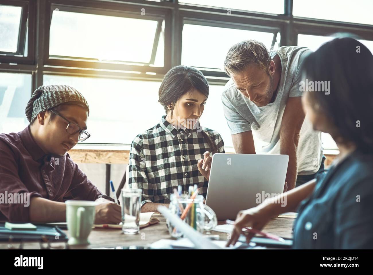 There is always something to learn and teach. Shot of a team of entrepreneurs collaborating in a modern office. Stock Photo