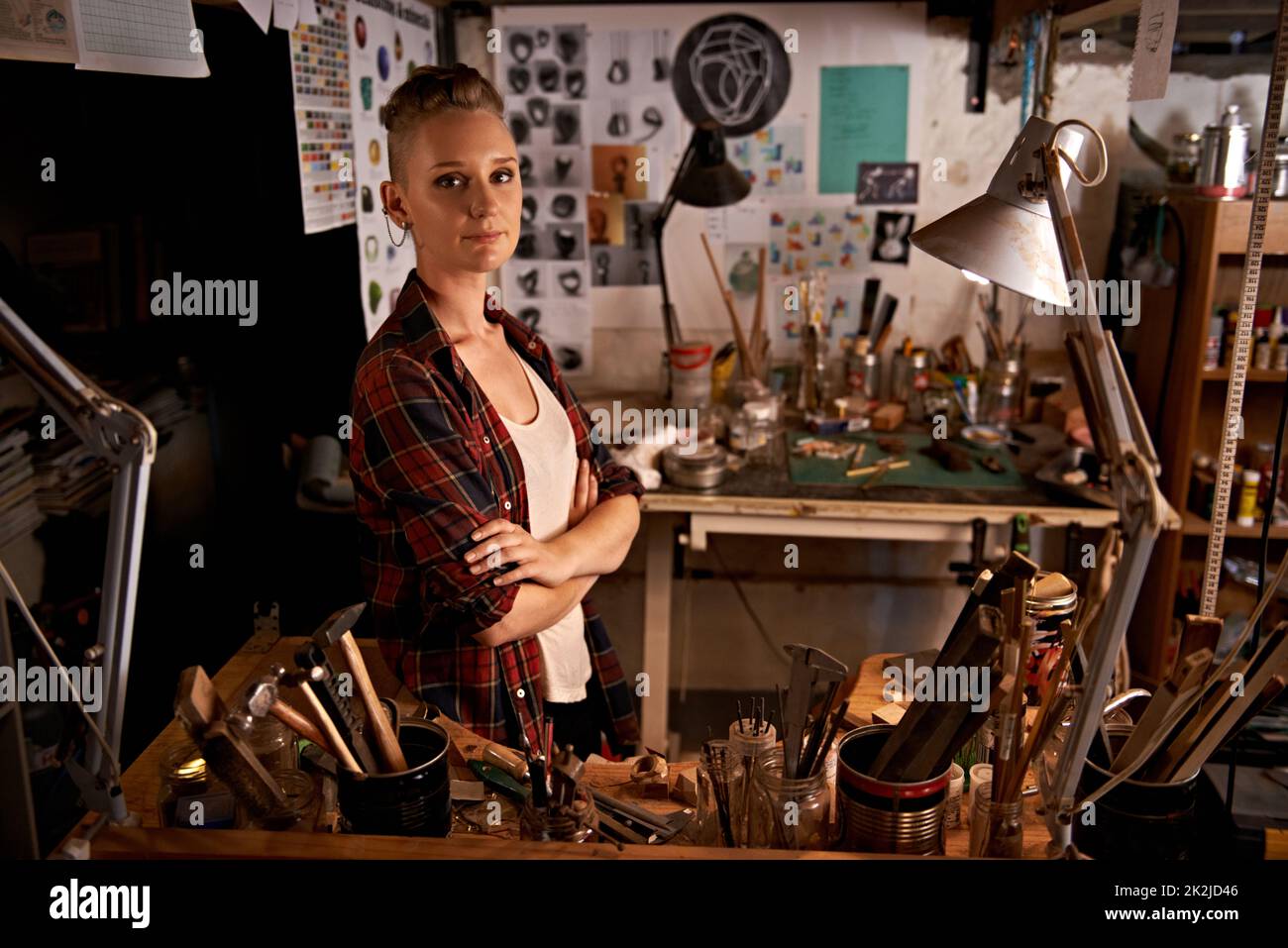 Organized chaos. Shot of a beautiful young woman sitting in a workshop. Stock Photo