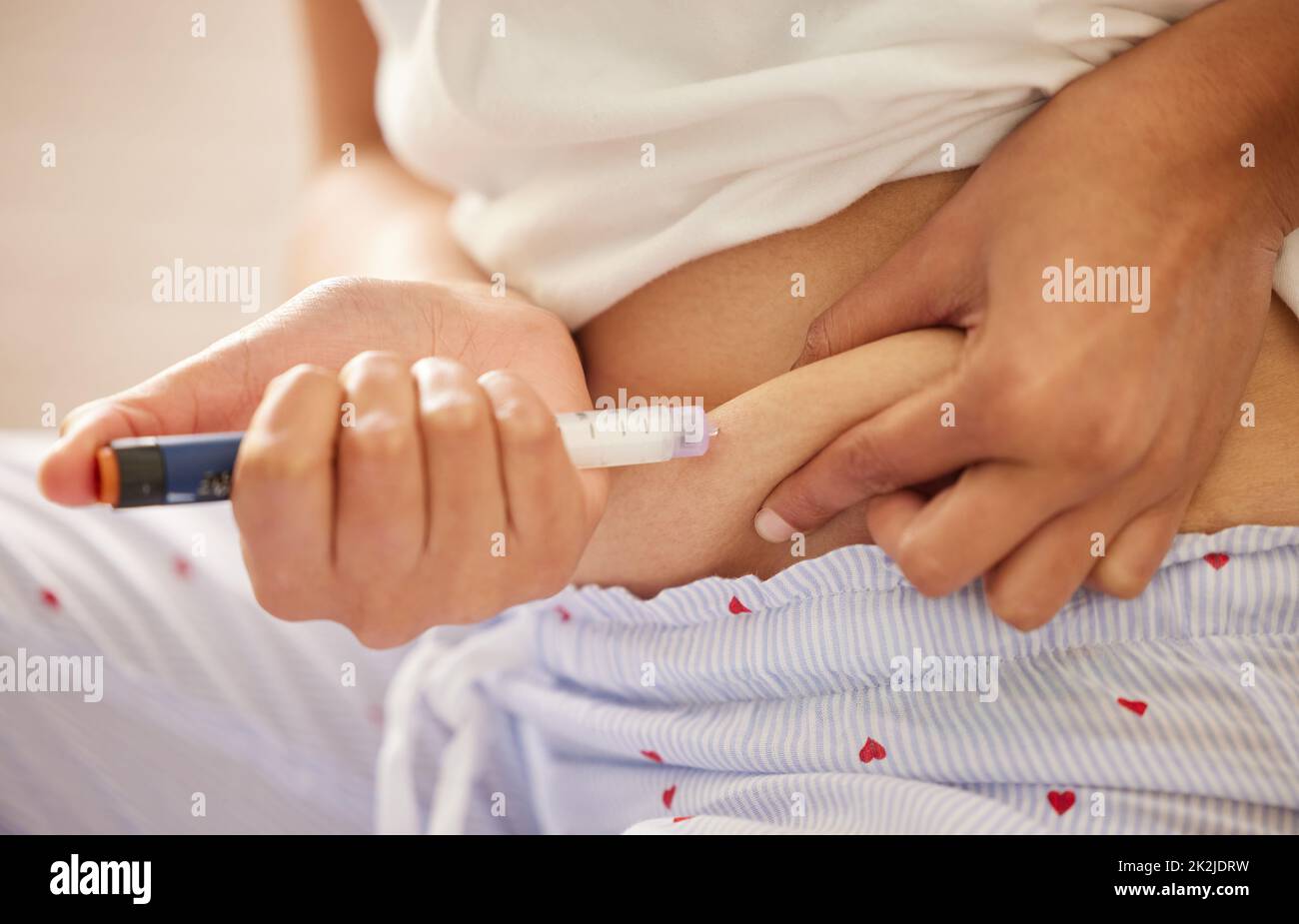 Time for some insulin. Closeup shot of an unrecognizable woman injecting herself in the stomach with insulin at home. Stock Photo