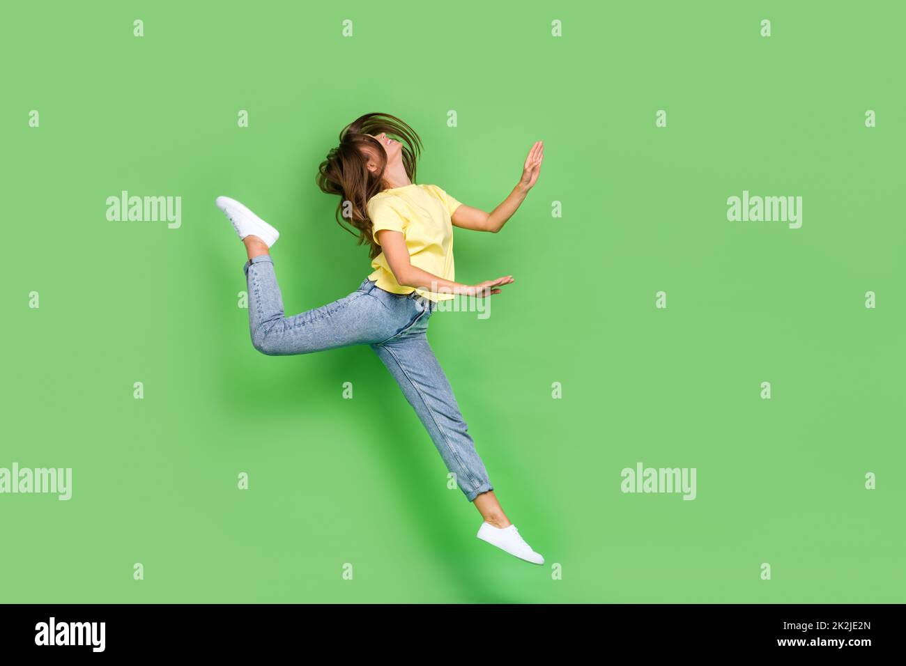 Full length photo of positive funky lady dressed comfy stylish clothes enjoy hobby time empty space isolated on green color background Stock Photo