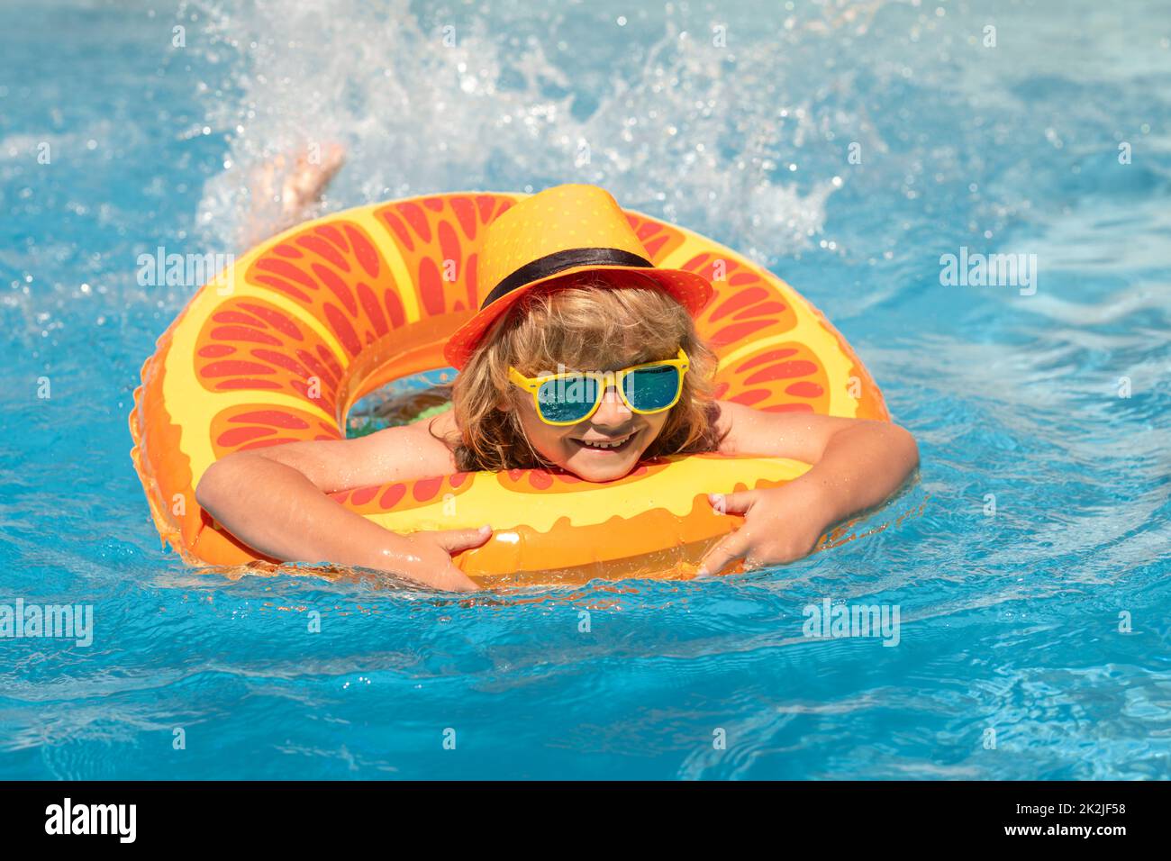 Kid boy relaxing in pool. Child swimming in water pool. Summer kids activity, watersports. Summer vacation with children. Stock Photo