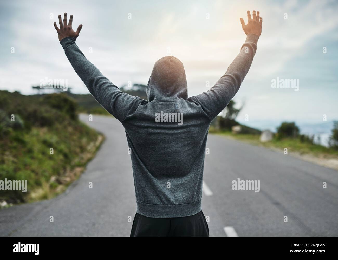Crushing his goals. Rearview shot of an unrecognizable young sportsman cheering in celebration outside. Stock Photo
