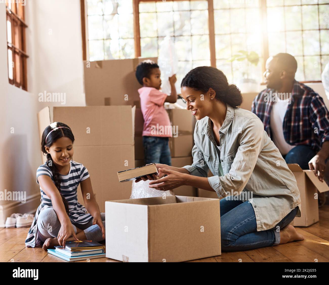 Its an exciting change for them all. Shot of a young family moving house. Stock Photo