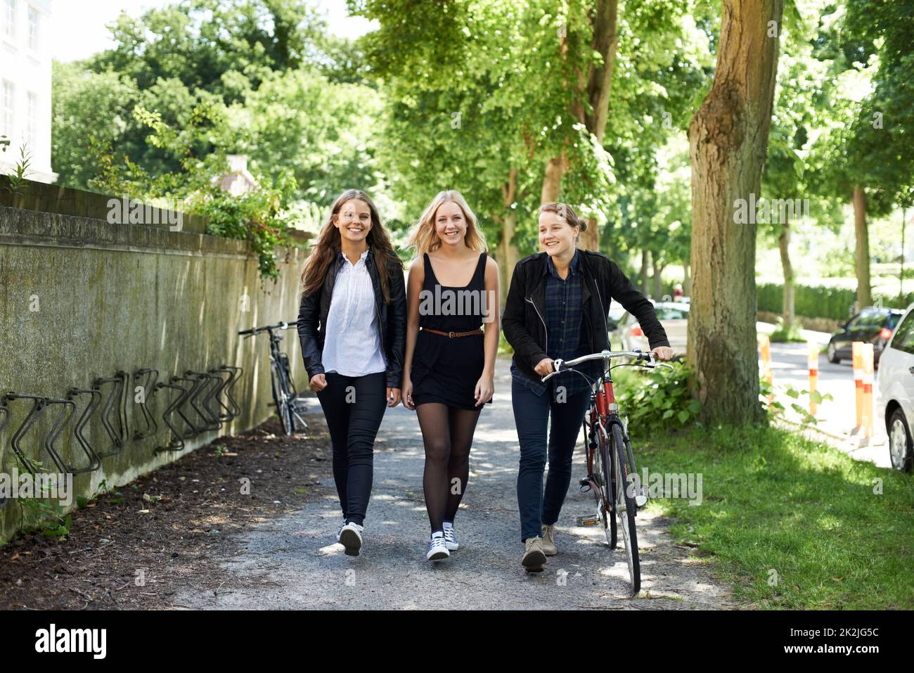 Catching up after school. Three friends walking home from school Stock
