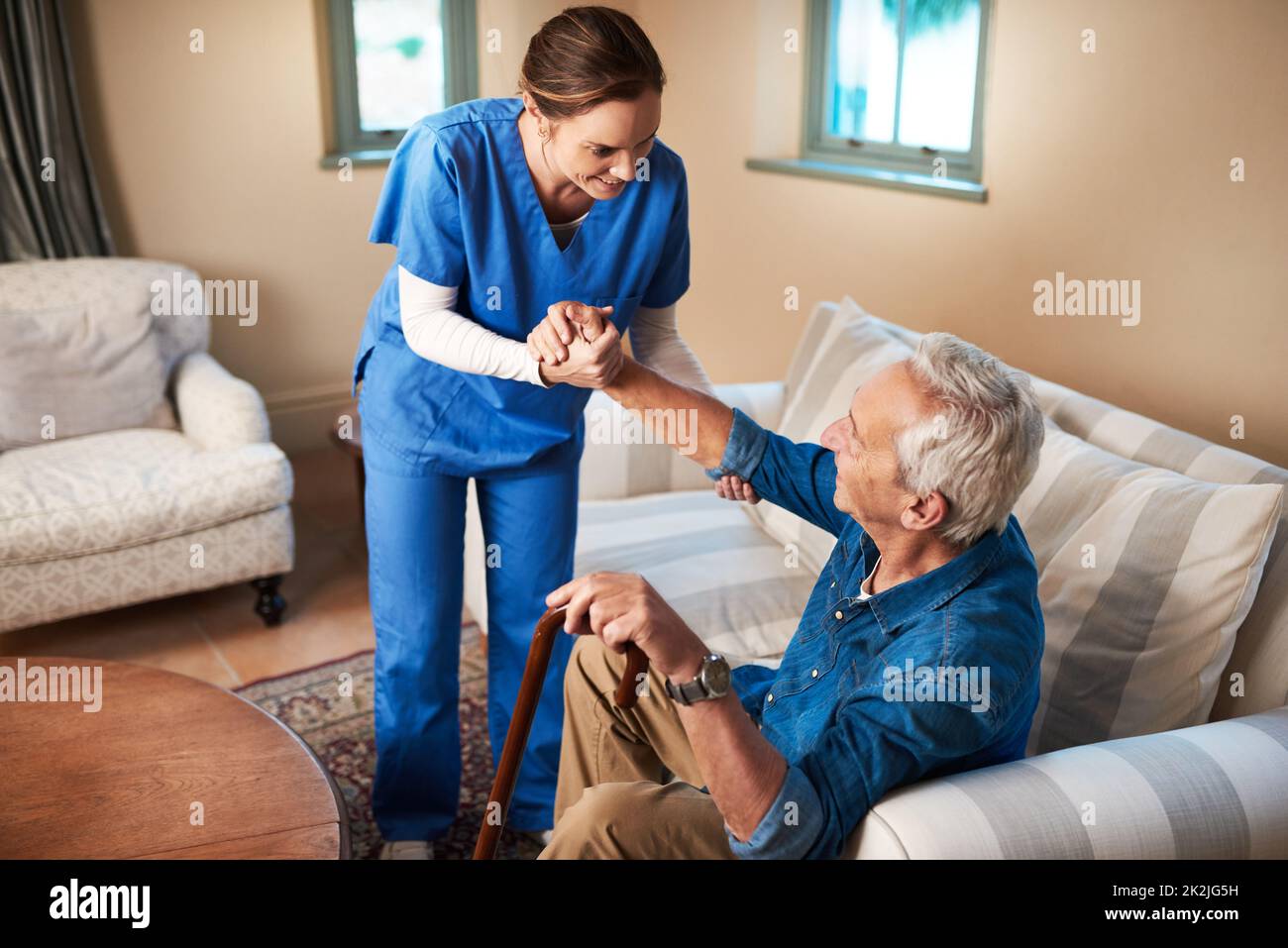 Her caring nature makes her the perfect caregiver. Shot of a caregiver assisting her senior patient at home. Stock Photo
