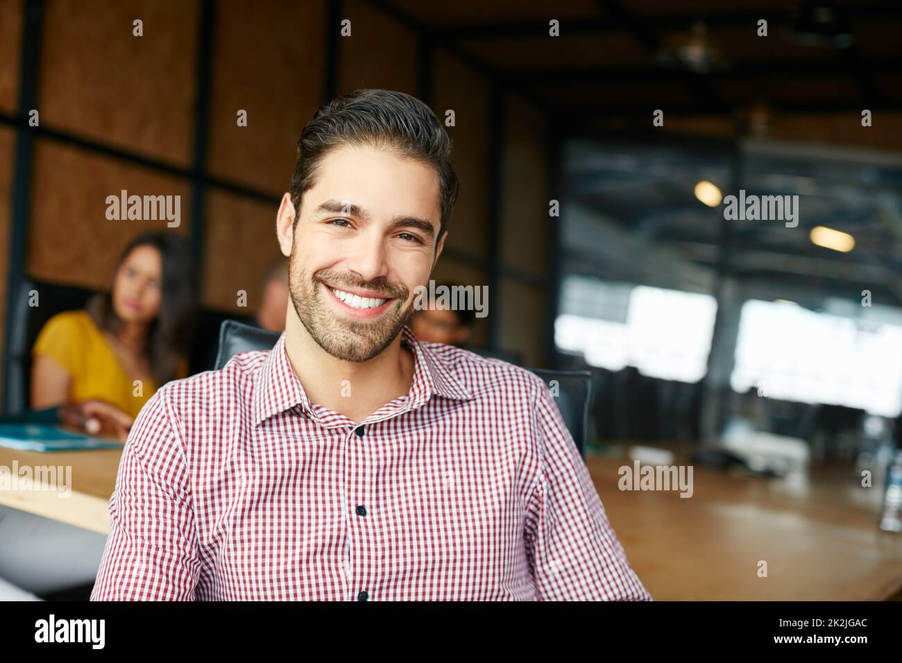 Make today so awesome yesterday gets jealous. Portrait of an office worker in a meeting with colleagues in the background. Stock Photo