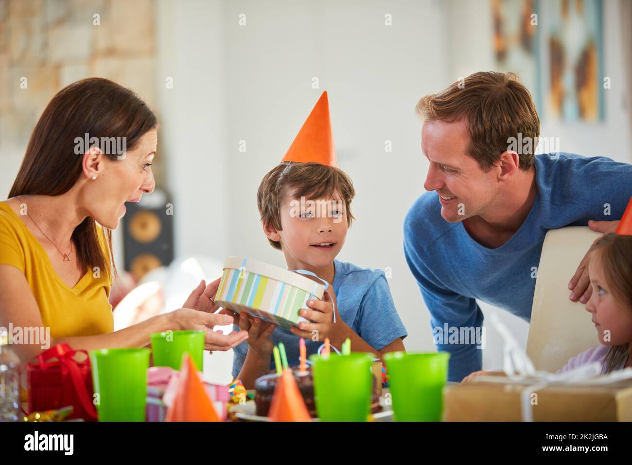 I think I know what this is. Shot of a little boy opening his birthday presents surrounded by his family. Stock Photo
