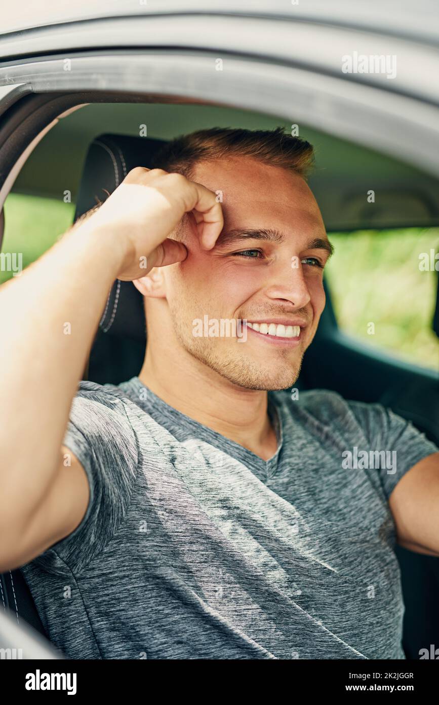 He enjoys the freedom of being on the road. Shot of a young man driving a car. Stock Photo